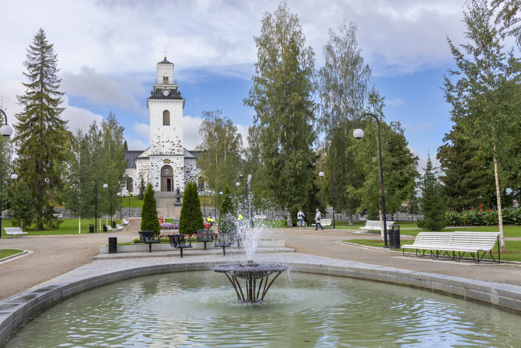 Kesäinen kuva Snellmaninpuistosta Tuomiokirkkoa kohti. Kuvan etualalla näkyy vesilähde.