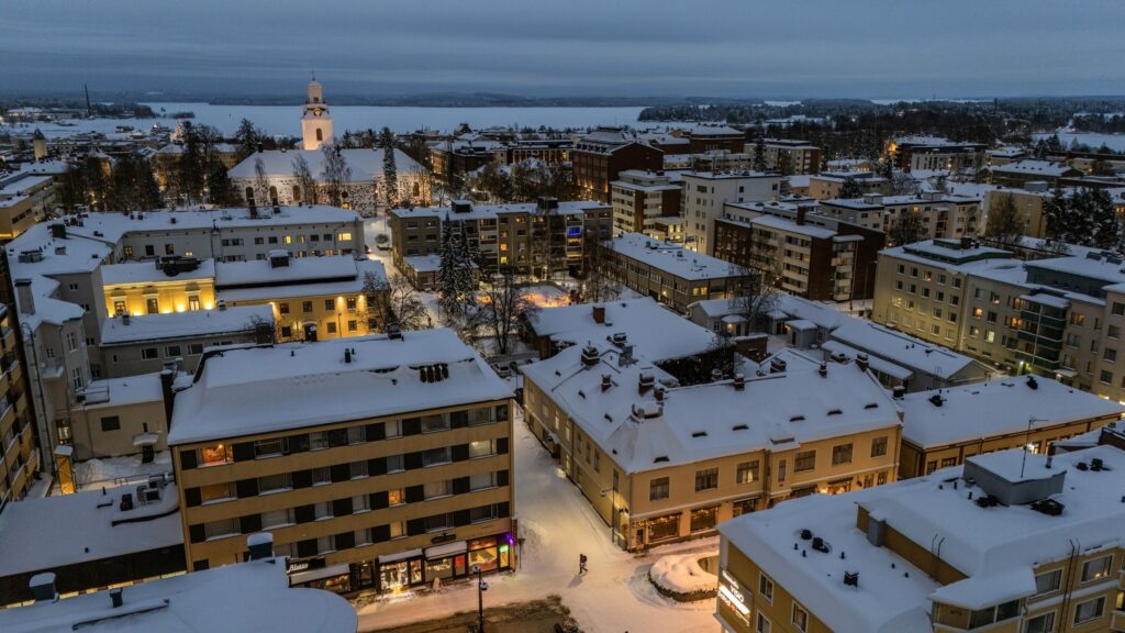 Ilmakuvassa kaupunkia hämärässä talvimaisemassa.