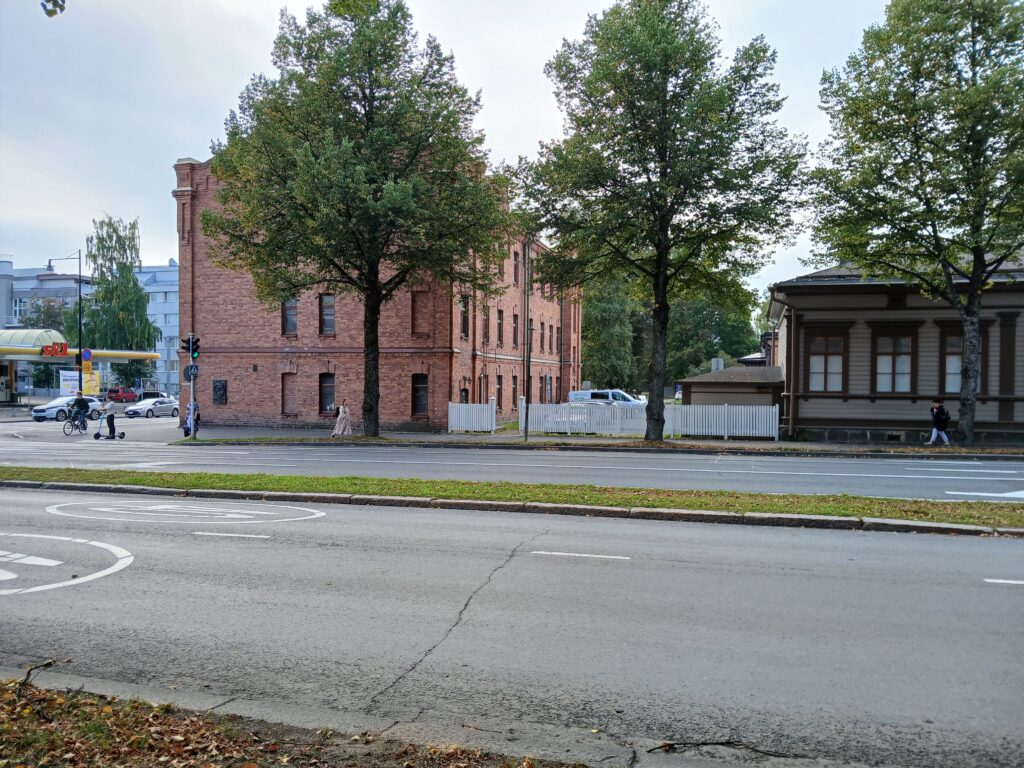 Kasarmialue, jossa näkyy vanhaa kasarmirakennusta ja polttoaineen jakeluasema Puistokadun suunnasta kuvattuna.