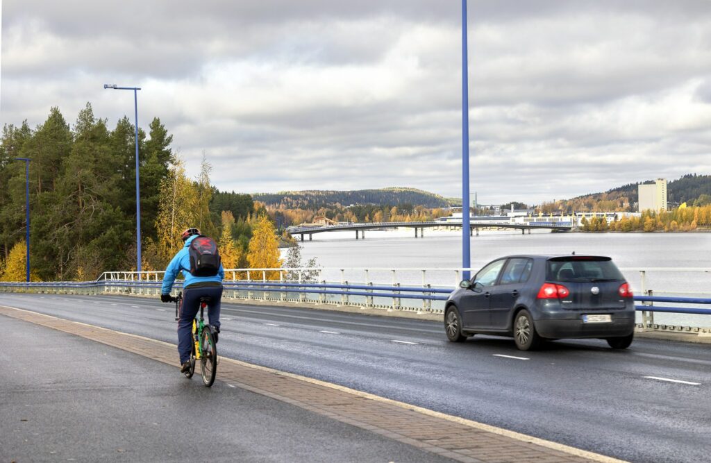 Syksyinen päivä Saaristokadulla, jossa musta henkilöauto ja pyöräilijä.