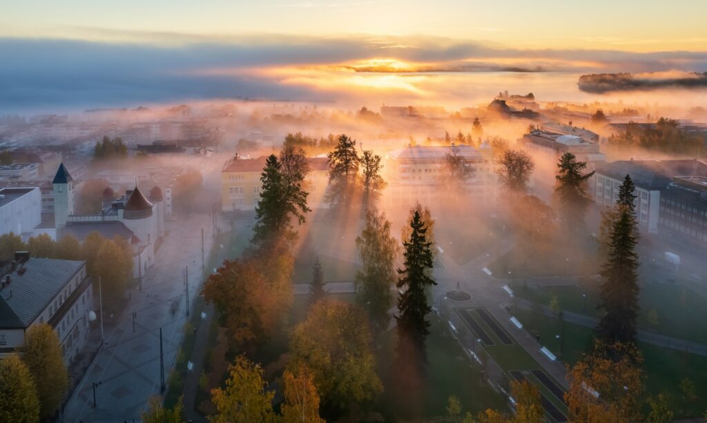 Auringonnousu usvaisen kaupungin yllä.