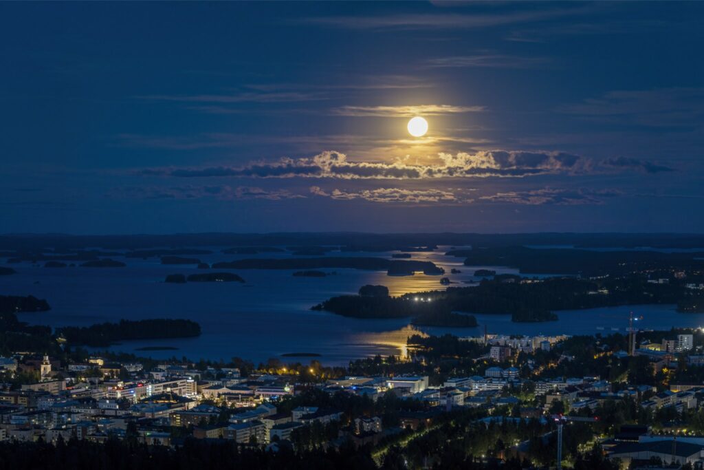 Kuutamo kaupungin yllä.