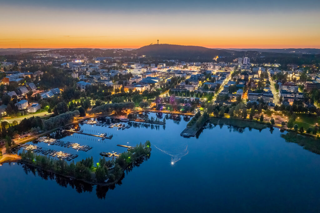 Kaupunkimaisema valoineen auringonlaskun aikaan.