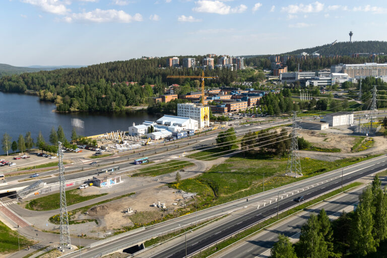 Järvi, luontoa, teitä ja uutta rakentamista. Taustalla Puijon torni.