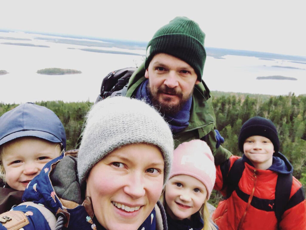 A family of three children and parents are hiking.